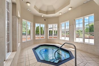 an indoor jacuzzi in a large room with windows